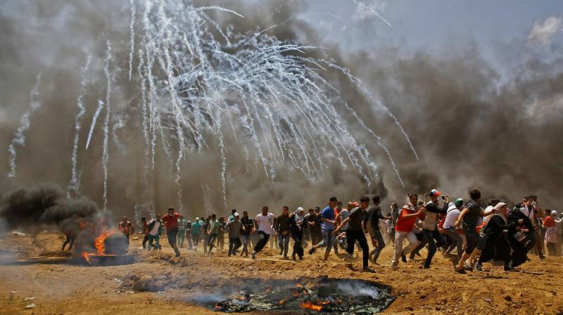 Palestinians run for cover from tear gas during clashes with Israeli security forces Palestinians run for cover from tear gas during clashes with Israeli security forces