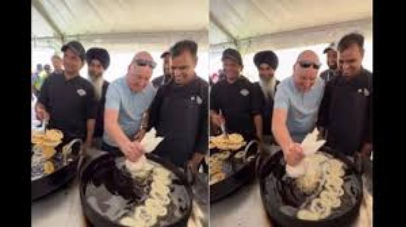 As he poured the batter into a large wok of hot oil, people around him cheered and recorded the moment. File Photo.