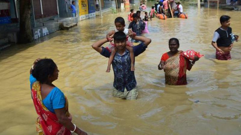 People wade through waterlogged streets