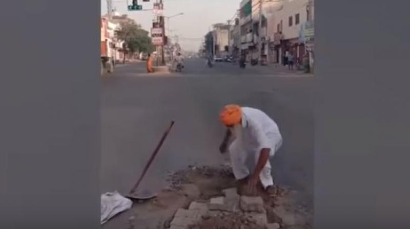 Sikh man filling potholes