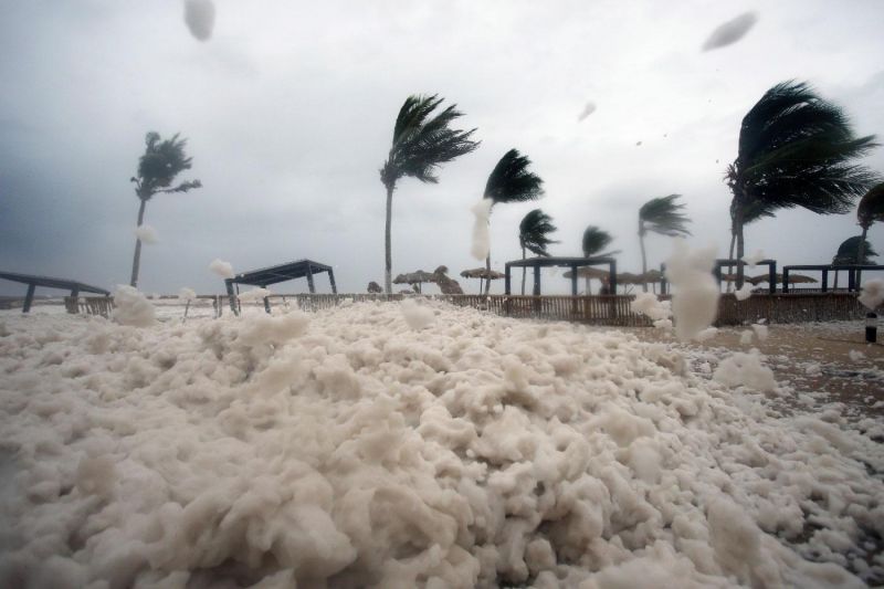Debris and sea foam litter a beach after Cyclone Mekunu