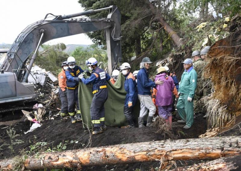 Japanese rescue workers with bulldozers and sniffer dogs scrabbled through the mud