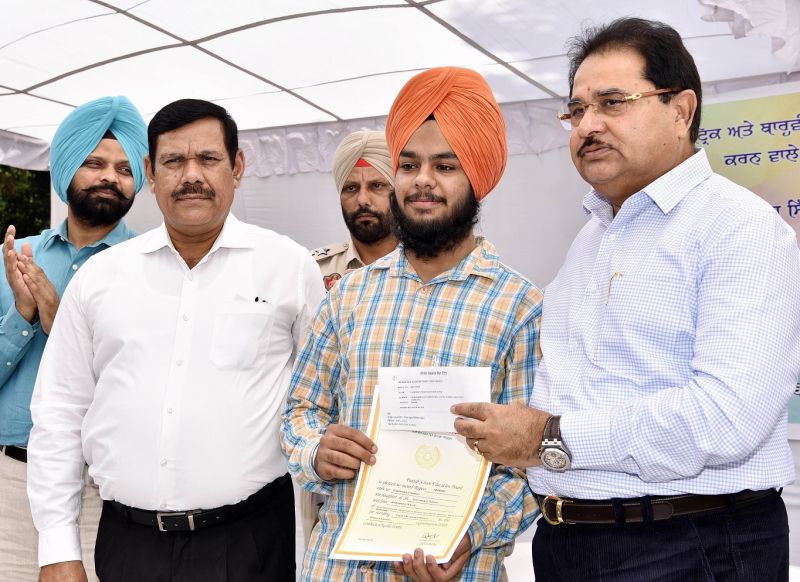 O.P Soni presenting cash award and commendation certificate to meritorious student of PSEB 2018 Exams