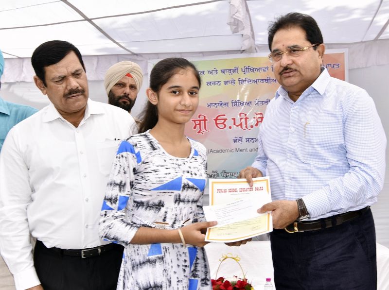 O.P Soni presenting cash award and commendation certificate to meritorious student of PSEB 2018 Exams