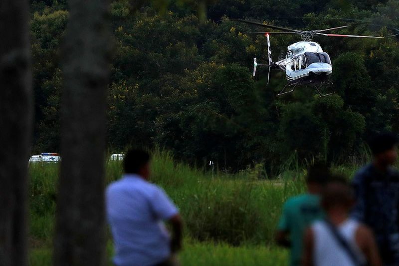 A helicopter carrying rescued schoolboys lands at a military airport 