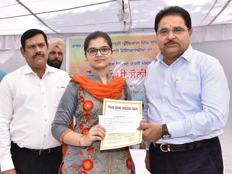 O.P Soni presenting cash award and commendation certificate to meritorious student of PSEB 2018 Exams
